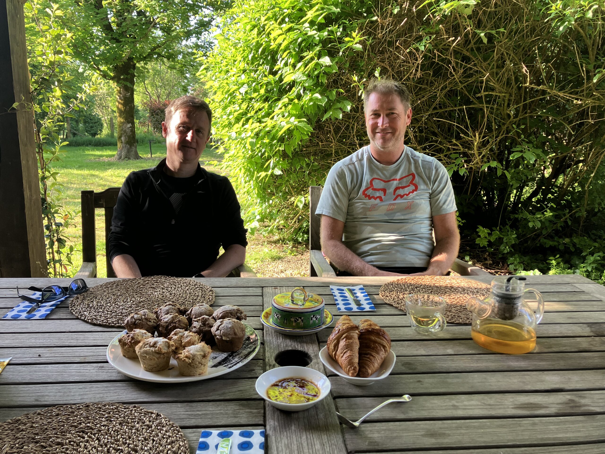 breakfast outside showing two men and lovely food on a table
