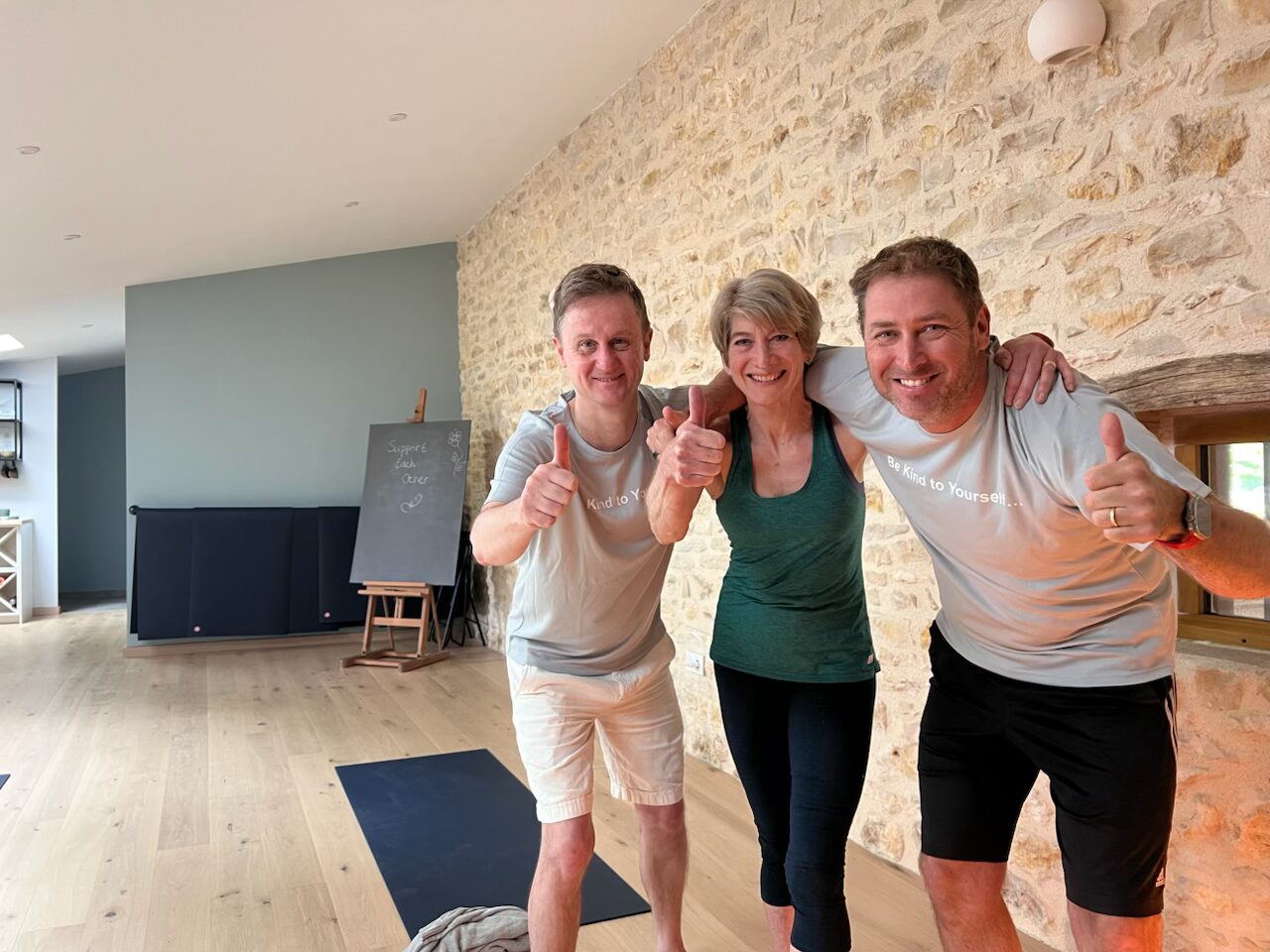Three people looking happy in a studio sharing a thumbs up to the camera